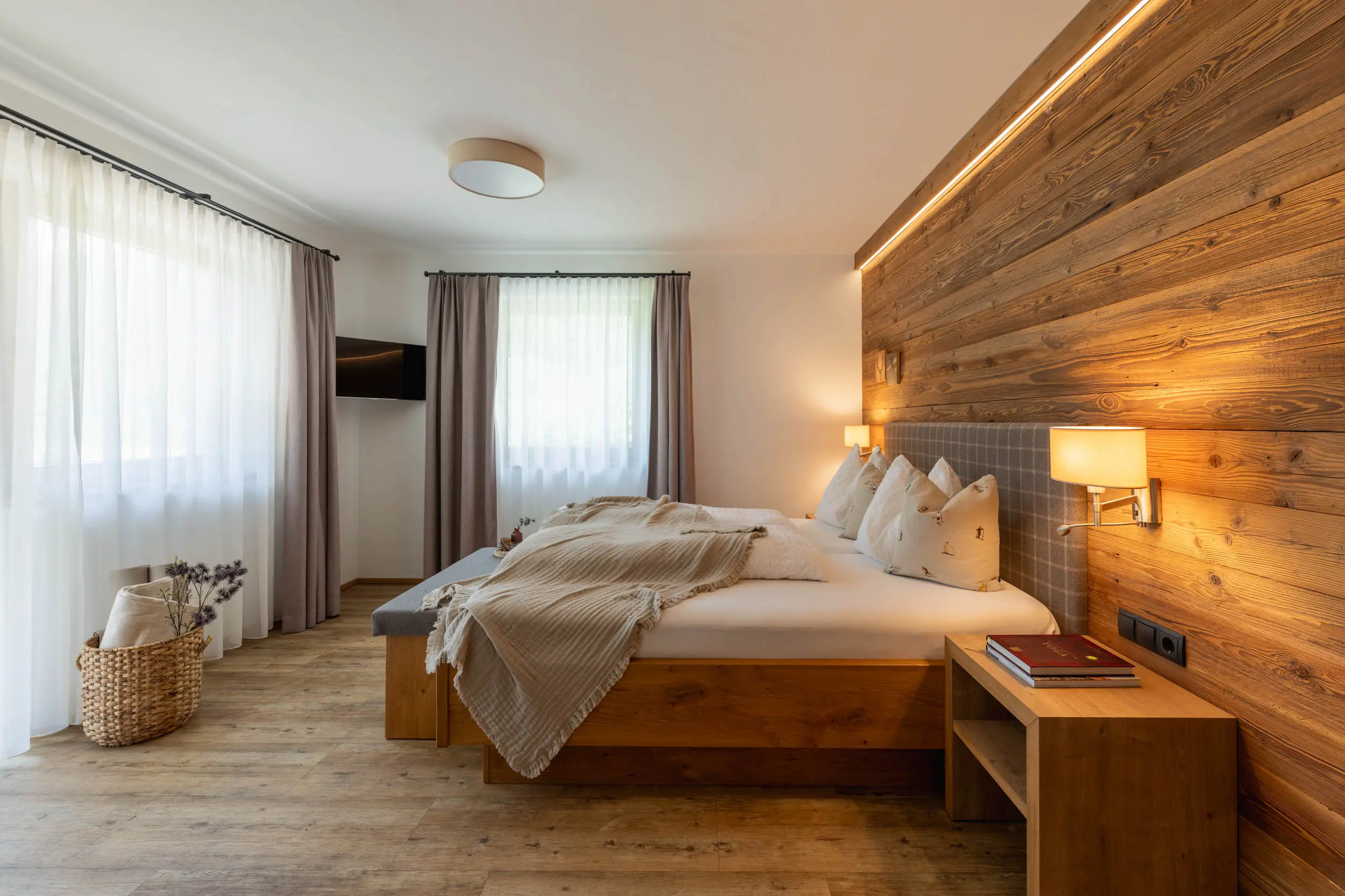 andreschoenherr__NZ80892-HDR Schlafzimmer mit Holzwand und Fenster im stoanmandl Appartement