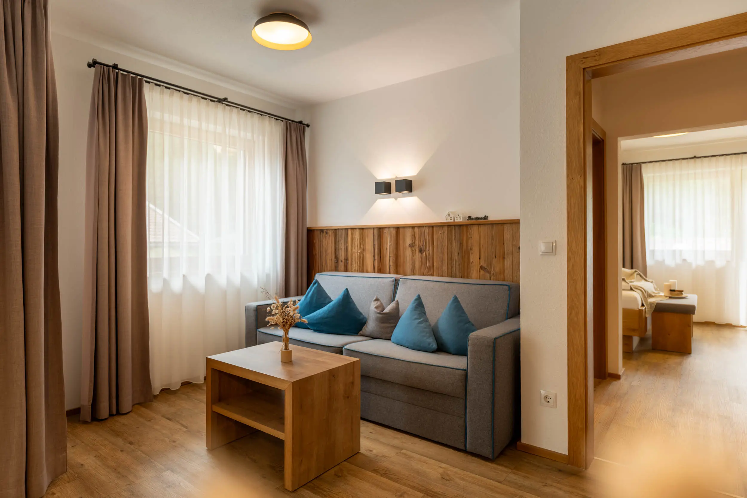 Wohnraum mit Sofa und Essbereich im stoanmandl Appartement